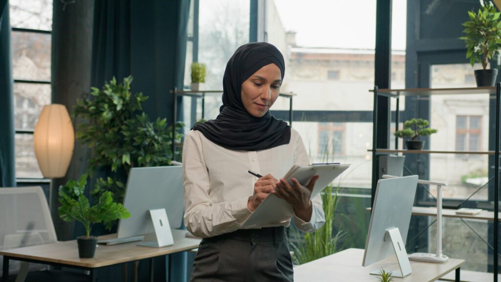 Happy muslim Islam woman Arabian girl in hijab HR manager secretary with paper tablet write notes